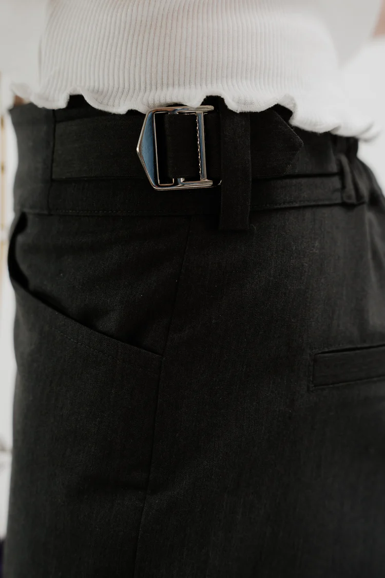 Close up of black boot cut trousers with elastic waist and invisible zips